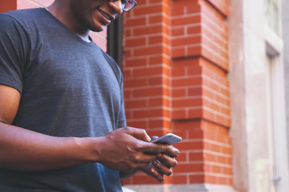 Hombre en la calle revisa una notificación en su celular