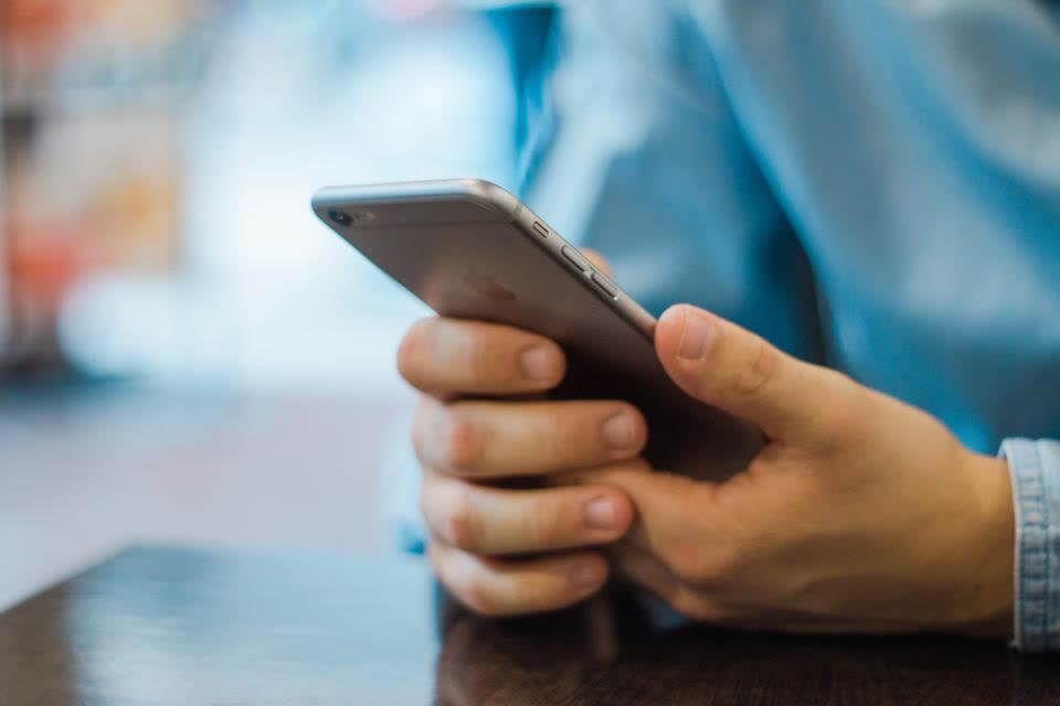 Primer plano de una persona usando su celular para confirmar un código